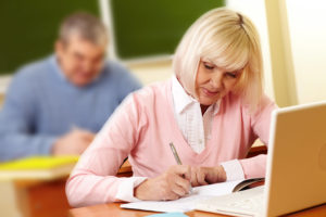 Image of adult learner writing
