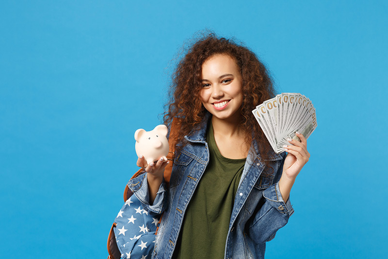 girl with money and pig bank in her hands