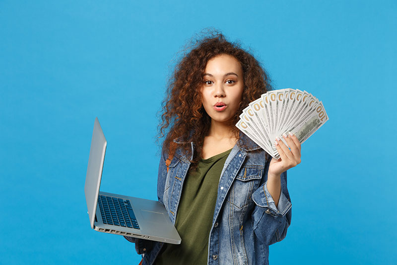 girl with money and laptop